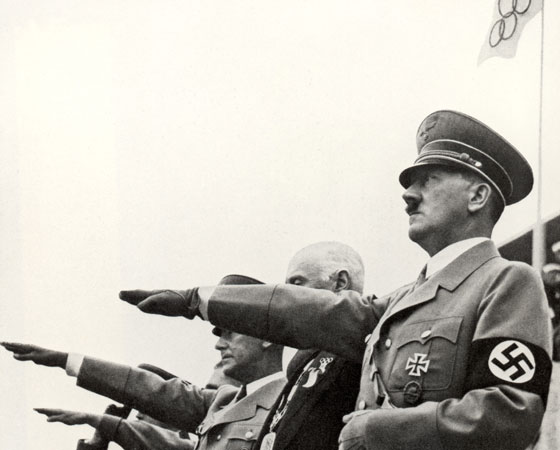 Em Berlim, Adolf Hitler quis mostrar a superioridade ariana no esporte, mas os negros americanos roubam a cena e ganharam várias medalhas. Há um mito de que Adolf Hitler teria se recusado a cumprimentá-los. Na foto: Hitler faz a saudação nazista na abertura do evento. Crédito: Getty Images Em Berlim, Adolf Hitler quis mostrar a superioridade ariana no esporte, mas os negros americanos roubam a cena e ganharam várias medalhas. Há um mito de que Adolf Hitler teria se recusado a cumprimentá-los. Na foto: Hitler faz a saudação nazista na abertura do evento. Crédito: Getty Images