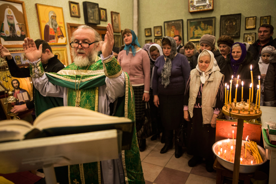 Grupo se reúne para orações em escritório de igreja ortodoxa russa em Donetsk, na Ucrânia. O salão principal da igreja foi destruído por um bombardeio em 2014, forçando a congregação a se reunir em um espaço improvisado desde então. (Foto: Andrew Burton / Getty Images). Grupo se reúne para orações em escritório de igreja ortodoxa russa em Donetsk, na Ucrânia. O salão principal da igreja foi destruído por um bombardeio em 2014, forçando a congregação a se reunir em um espaço improvisado desde então. (Foto: Andrew Burton / Getty Images).
