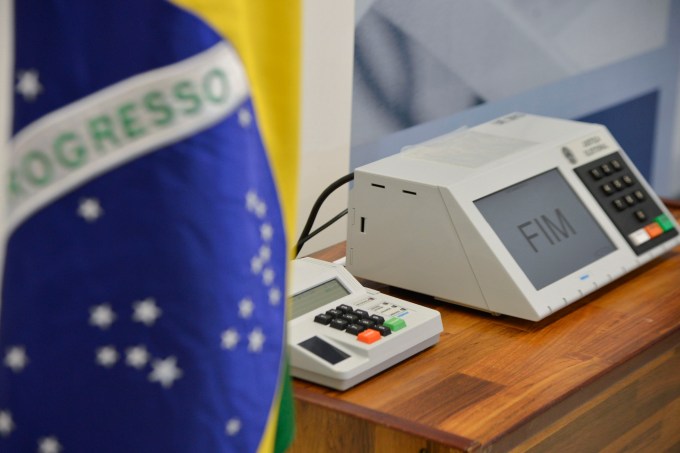 Urna eletrônica e bandeira do Brasil