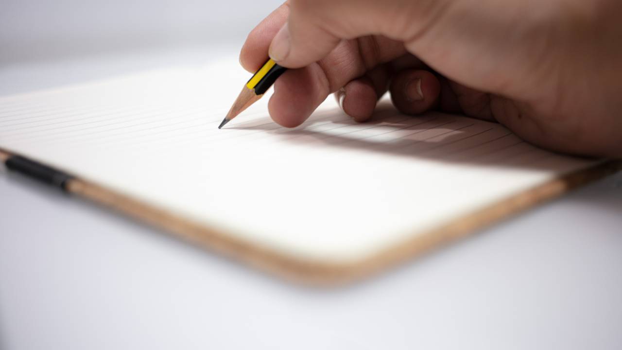 Estudante escrevendo no caderno