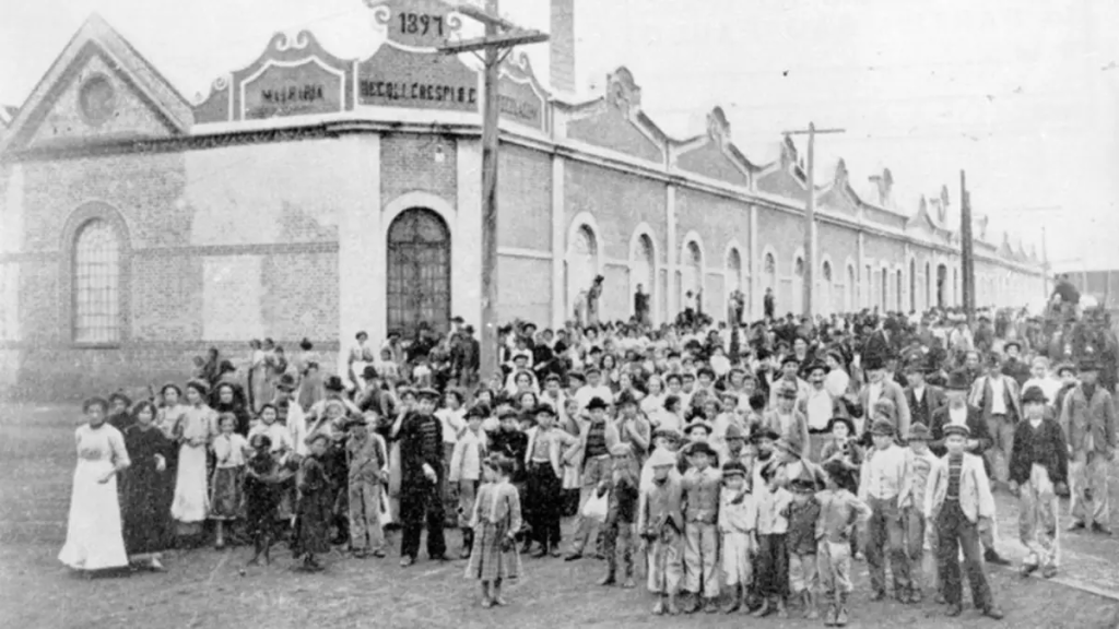 Homens e mulheres paralisam trabalho em frente a fábrica têxtil, em 1917. São Paulo.