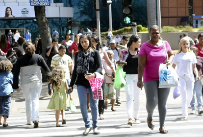 População caminha em cidade; compras; centro urbano