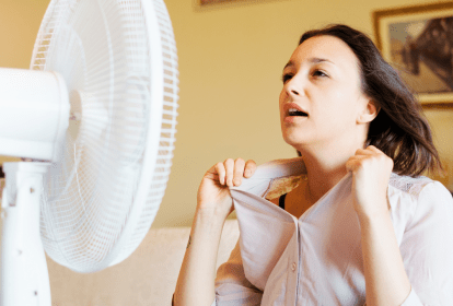 Mulher suando em frente a um ventilador