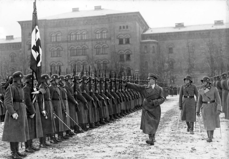 Adolf Hitler desfila entre soldados enfileirados.