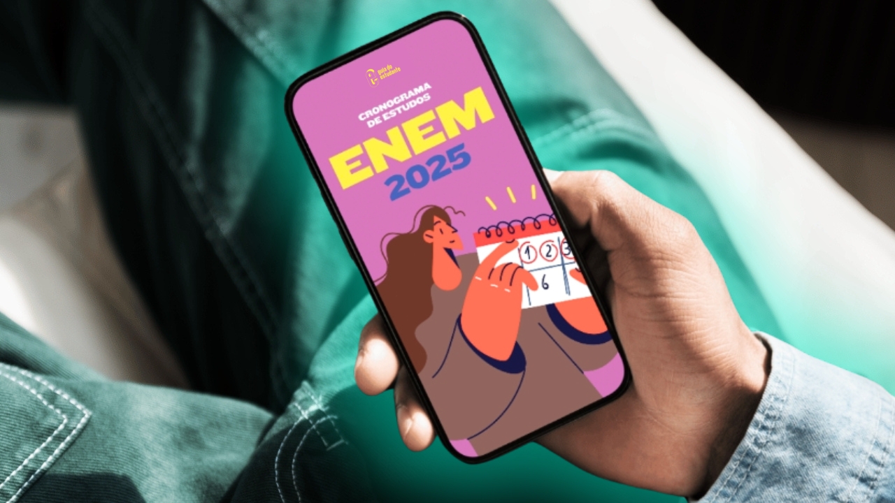 Mão segurando celular com cronograma de estudos do Enem 2025 aberto